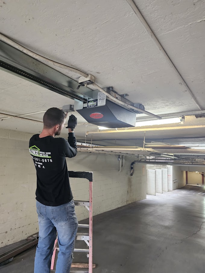 Silence technician on a ladder servicing a ceiling-mounted garage door opener