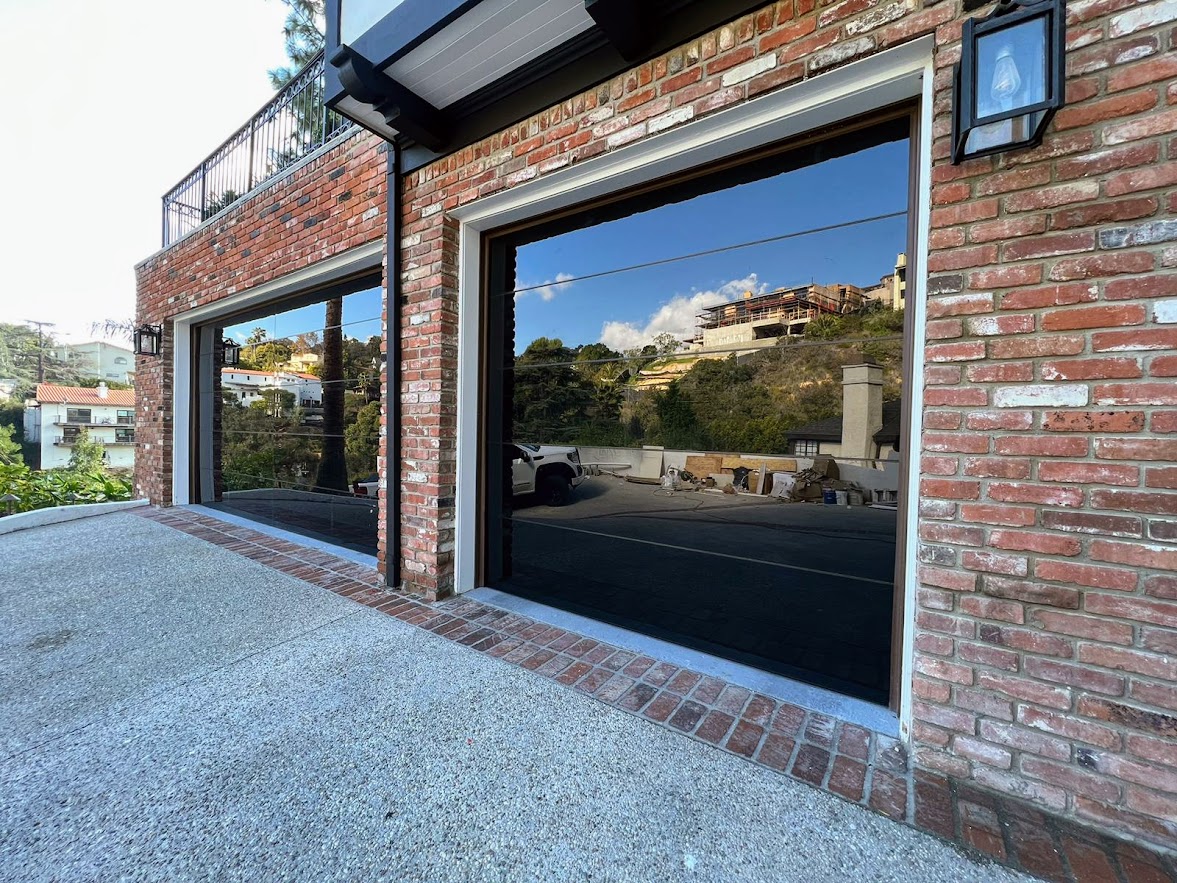 Los Angeles. One-car and two-car garage doors, full view, frameless black glass, LiftMaster jackshaft opener.