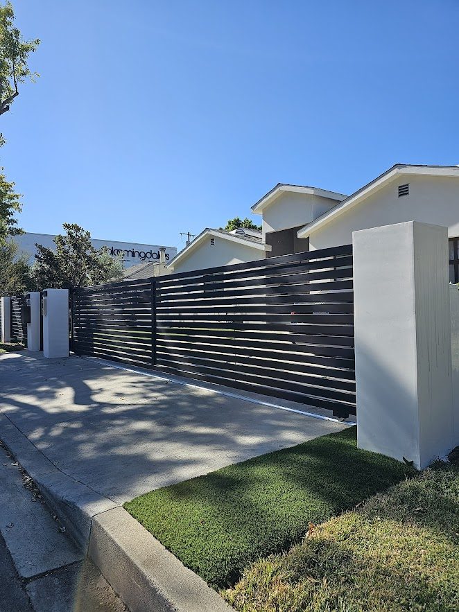 Sherman Oaks. Concrete columns, smooth stucco, intercom system, sliding gate, horizontal-slat fence.