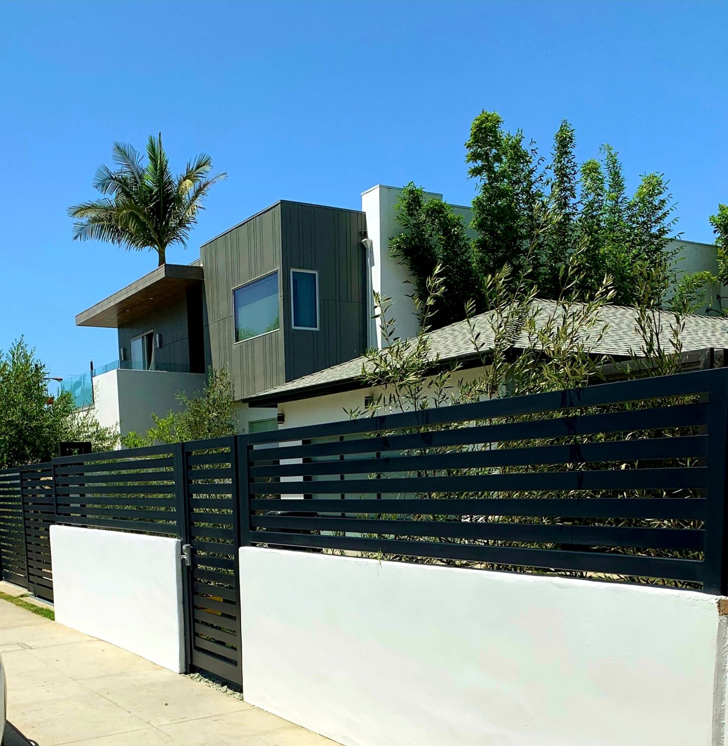 Culver City. Smooth stucco block wall, horizontal-slat metal fence, telescoping gate with pedestrian gate.