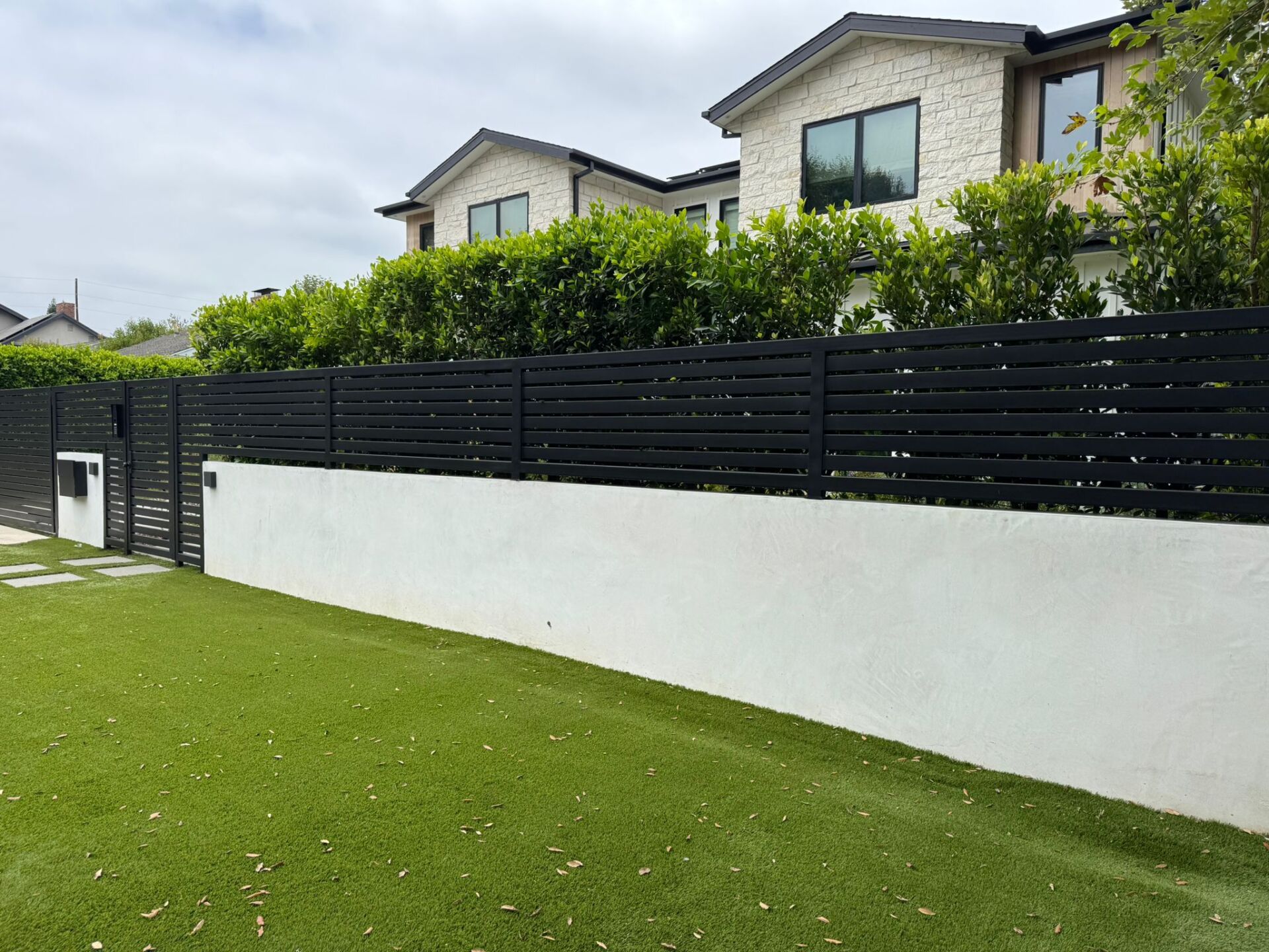 North Hollywood. Smooth stucco block wall, horizontal-slat fence, double swing gate, LiftMaster motor, intercom system.