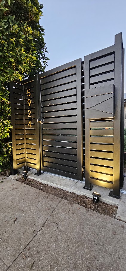 Horizontal-slat metal pedestrian gate, two fixed panels, base uplighting. Encino.