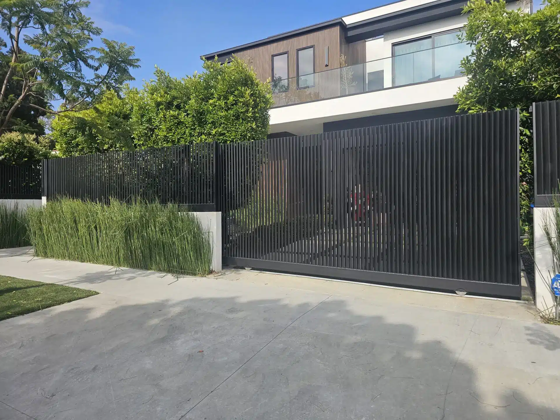 Wrought iron driveway gate between stone columns